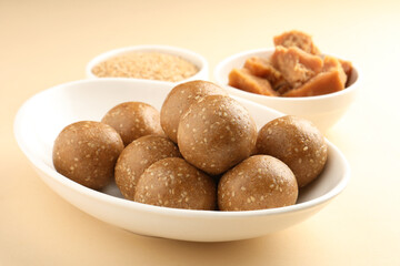 Tilgul Laddu or Til Gul balls for makar sankranti, it's a healthy food made using sesame, crushed peanuts and jaggery. served in a bowl. selective focus showing details.