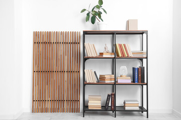 Bookshelf and folding screen near light wall in room