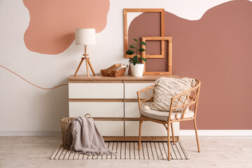 Interior of living room with armchair and lamp on commode