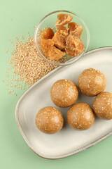 Tilgul Laddu or Til Gul balls for makar sankranti, it's a healthy food made using sesame, crushed peanuts and jaggery. served in a bowl. selective focus showing details.