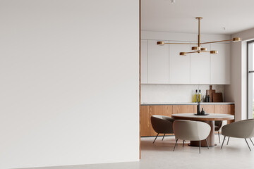 Minimalist kitchen interior with blank wall, wooden cabinets, round dining table, and modern lighting fixture in a bright, luxury home. 3D Rendering