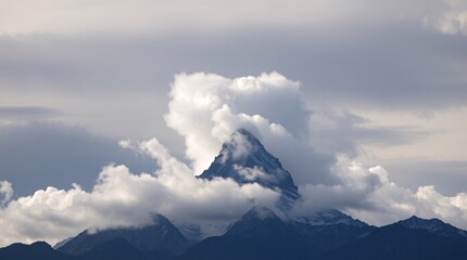 A breathtaking view of a towering mountain peak partially obscured by dense clouds against a radiant and vivid blue sky, evoking a sense of awe and natural beauty