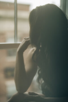 Silhouette of a woman by window, soft focus with a dreamy atmosphere