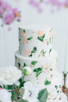 Three-tier floral wedding cake with buttercream decorations.
