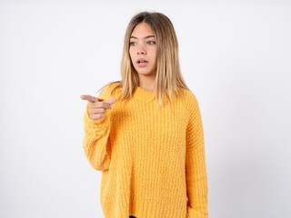 Funny beautiful caucasian teen girl wearing orange sweater People sincere emotions lifestyle concept. Mock up copy space. Screaming in megaphone.