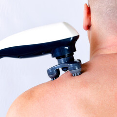 Electric Massager Relieving Tension on a Bare Shoulder © dimas830