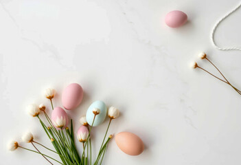 Minimalist arrangement of pastel Easter eggs with white flowers and green stems on a clean white marble background for a serene spring aesthetic
