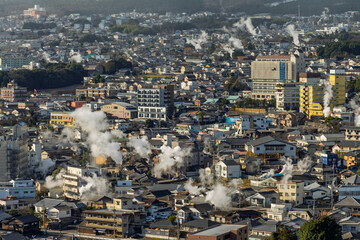 Fototapeta premium Beppu cityscape with Steam drifted from public hot spring baths and ryokan onsen background, Beppu, Oita, Kyushu, Japan.