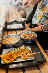 Family queue to order and choose various meals from menu for dining at a Japanese restaurant