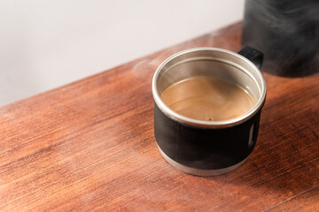 Steaming Coffee in Black Mug on Wooden Table