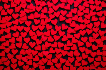 Small red heart shaped cutouts cover frame with dark background