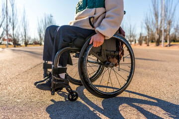 Young person moving on wheelchair in park during sunset