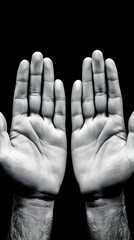 Open Hands Reaching Outward on Dark Background: A Monochrome Photo