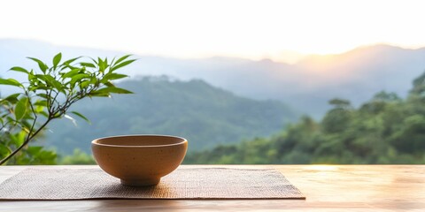 Holistic wellbeing concept. A serene landscape with a bowl overlooking lush mountains at sunrise.