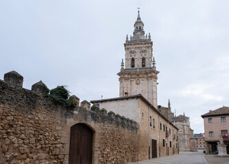 Fototapeta premium cobbled street in the medieval village of Burgo de Osma in Soria with the bell tower of the Cathedral of the Assumption of the Virgin, Virgen de la Asuncion