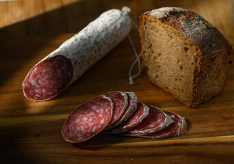 Artisan cured meat and fresh bread on a rustic wooden cutting board in soft afternoon light