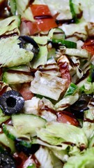 Vegetable salad with olives and balsamic dressing close-up. Spring food. Simple spring lunch