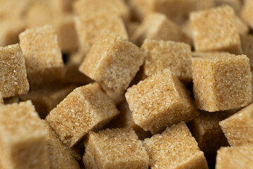 Macro cubes of brown cane unrefined dry demerara sugar.