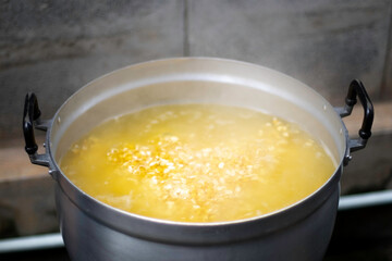 Close up of cooking or boiling soy beans in a pot selective focus blur background