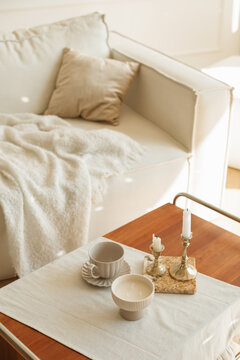 Overhead view of a stylish living room with a coffee table and a comfortable sofa with a blanket and cushion