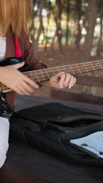 Girl Takes Sheet Music On Table With Bass Instrument In Nature