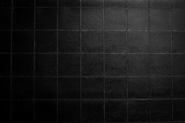 Black stone background with imitation tiles. Top view. Free space for text or design.