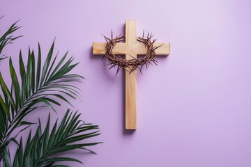 Fototapeta premium Wooden cross with crown of thorns and palm leaf on violet background. Good Friday concept 