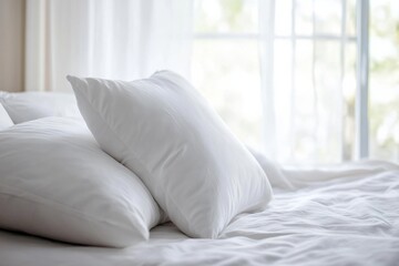Two white comfortable pillows laying on bed with white sheets in sunlit bedroom