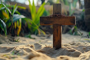 Wooden cross with crown of thorns in the sand. Good Friday concept 