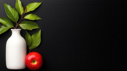 A white vase with a red apple next to it
