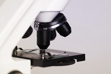 Science. Microscope with glass slide on light grey background, closeup
