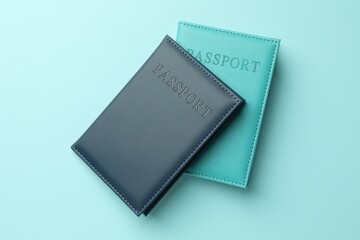Obraz premium Passports in color covers on light blue background, top view