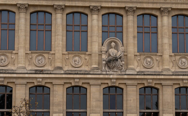 Architectural details of a historic building with stone sculptures in a city center