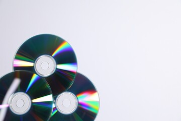 Shiny compact discs on light background, top view. Space for text