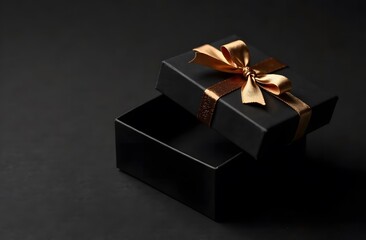 First person top view photo of hand holding black giftbox with yellow satin ribbon bow over shiny golden sequins on isolated black background with empty space