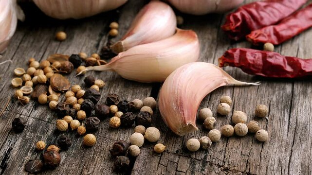 Garlic, dried chilli and pepper on a wooden table.