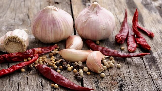 Garlic, dried chilli and pepper on a wooden table.