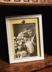 Old wedding photo displayed on shelf with yellow checkered frame