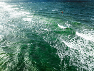Obraz premium Kitesurfer on big waves at Baltic Sea in summer.