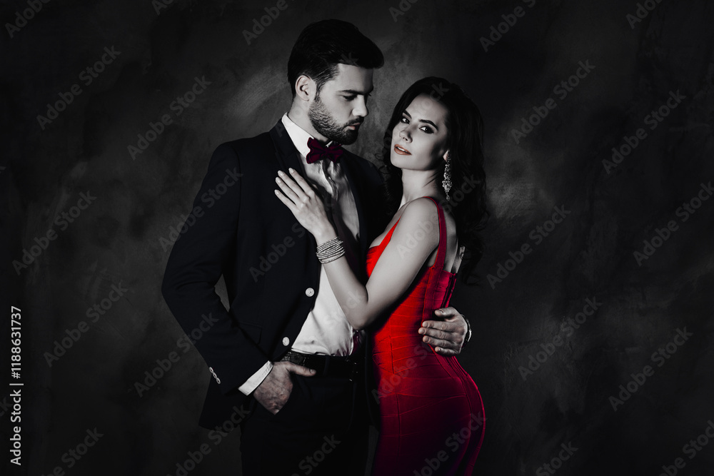 Poster portrait of man with stubble in tux with bowtie holding hand in pocket of pants looking at his charm
