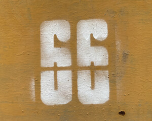 White number 66 on textured background. Sixty-six