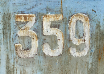 White number 359 on textured background with old paint