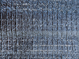 A texture of thermal insulated food packaging. Silver surface. Thick aluminum foil 