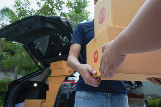 Close-up of worker's hand delivering parcel box to customer at home. Standard delivery service concept.