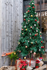 A beautifully decorated Christmas tree stands as the centerpiece of holiday celebration, adorned with twinkling lights, shimmering ornaments, and a glowing star at the top. Surrounded by wrapped gifts
