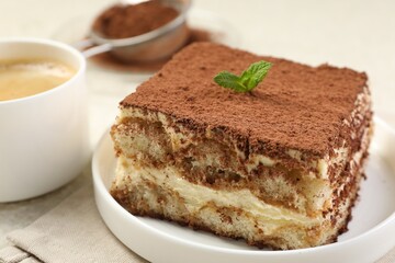Delicious tiramisu with mint on light table, closeup