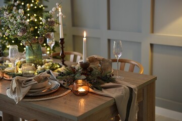 Christmas celebration. Festive table setting with dishware, glasses and decor in room