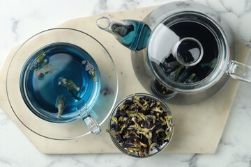 Delicious butterfly pea flower tea on white marble table, top view