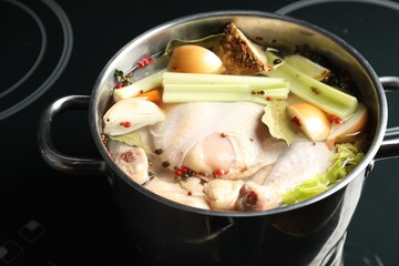 Whole fresh turkey, cut onion, celery and spices in pot on stove, closeup