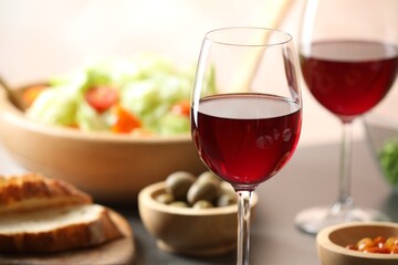 Red wine and delicious dinner served on table, closeup. Space for text